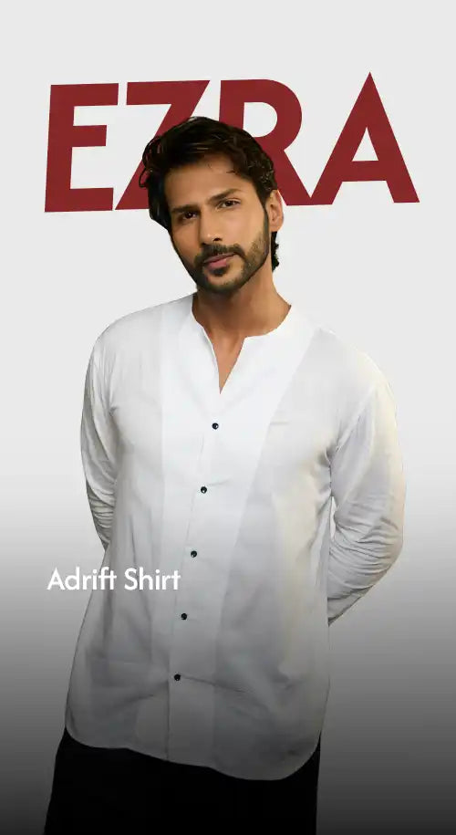 A man modeling a white collared shirt with black buttons.